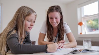 Mentor hjelper mentee med oppgavene til leksehjelp